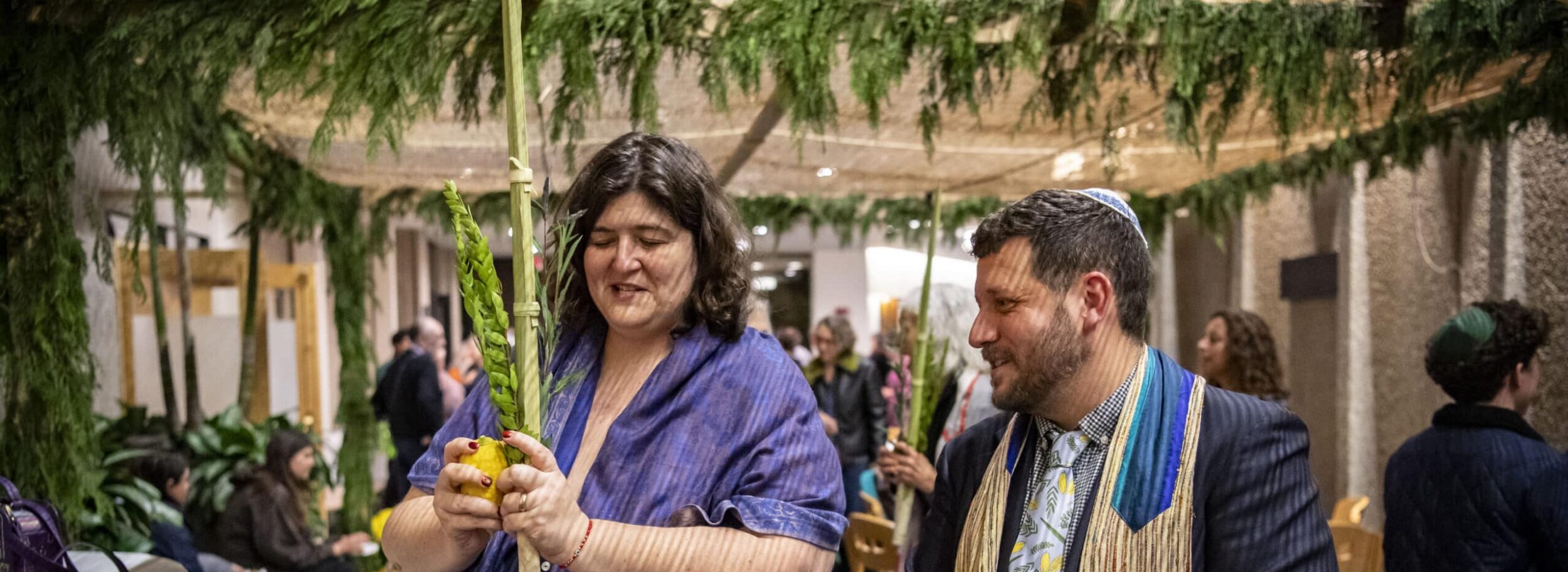Rabbi Slipakoff showing a congregant how to shake the lulav in the Sukkah