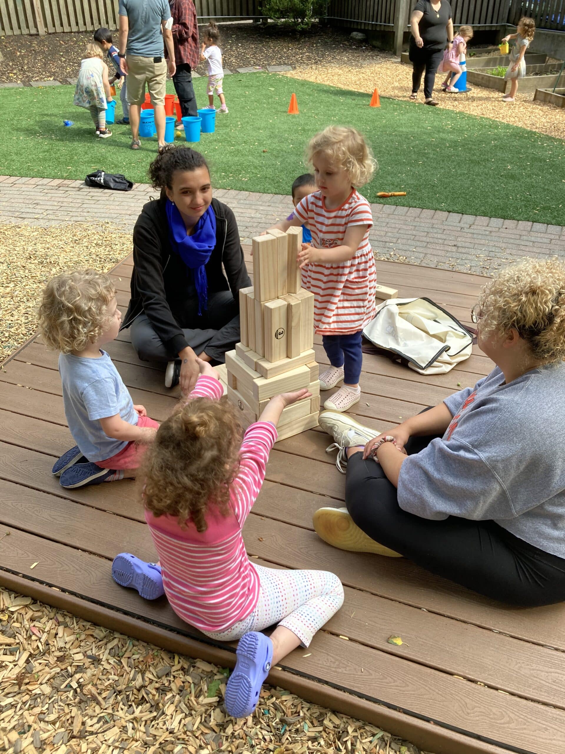 Children building a structure of blocks outdoors in the garden
