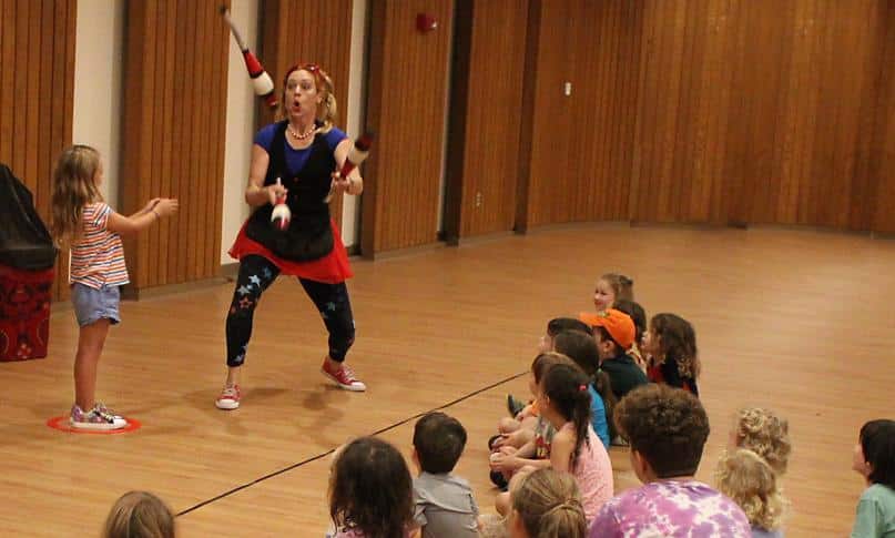 A juggler performing for a group of campers