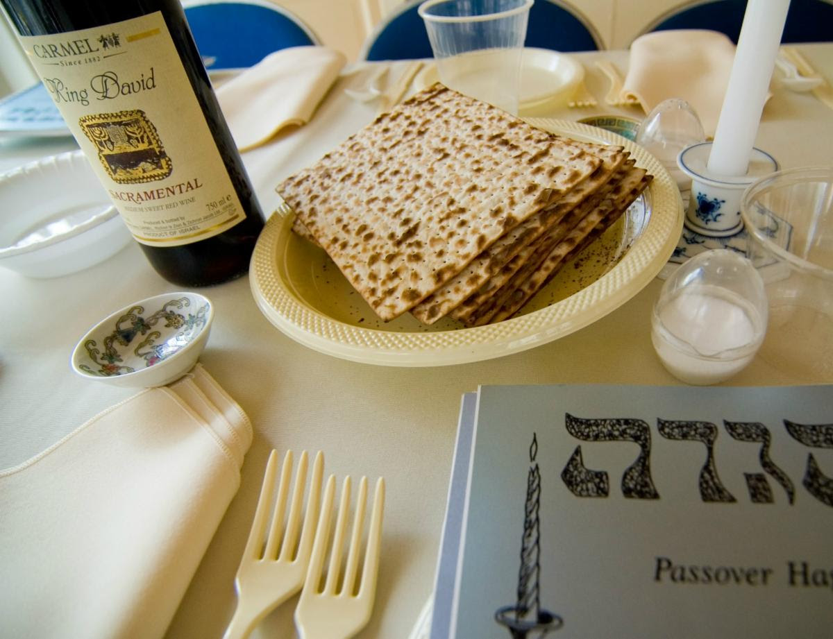 A Seder table with matzah, a bottle of wine and a hagaddah