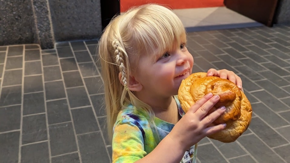 Young child holding a home baked challah in her hands
